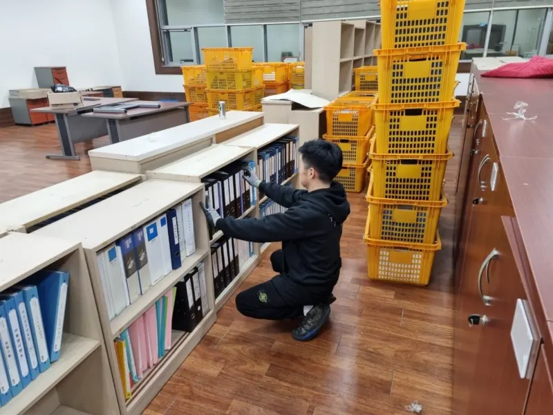 사무실 이사 현장에서 서류를 크레이트에 순서대로 담는 작업자